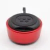 Compact red and black portable Bluetooth speaker with circular buttons and USB-C charging port.