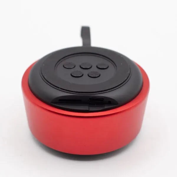 Compact red and black portable Bluetooth speaker with circular buttons and USB-C charging port.