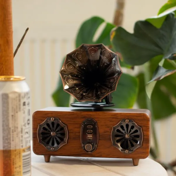 Vintage Wooden Gramophone Speaker - Brown With Golden Horn Retro wooden gramophone speaker with golden horn on table beside houseplant and aluminium can.