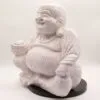 A crackle-glazed Laughing Buddha statue sitting cross-legged on a black base, smiling peacefully.