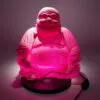 Boho Chic - Ambient Lighting gifts - Illuminated pink Laughing Buddha statue lamp with glowing belly on a dark circular base.