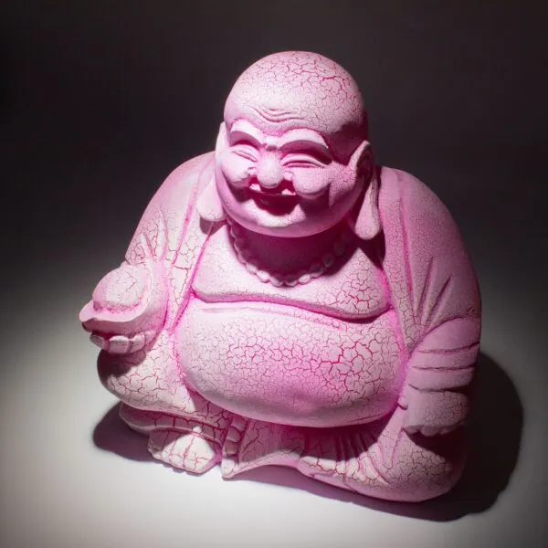 A bright pink cracked Laughing Buddha statue with a beaded necklace and round orb.