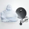 A pale blue laughing Buddha statue beside a black circular electric lamp base on a white background.