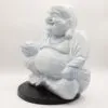 Light blue crackle-glazed Laughing Buddha statue seated cross-legged on a dark circular base.