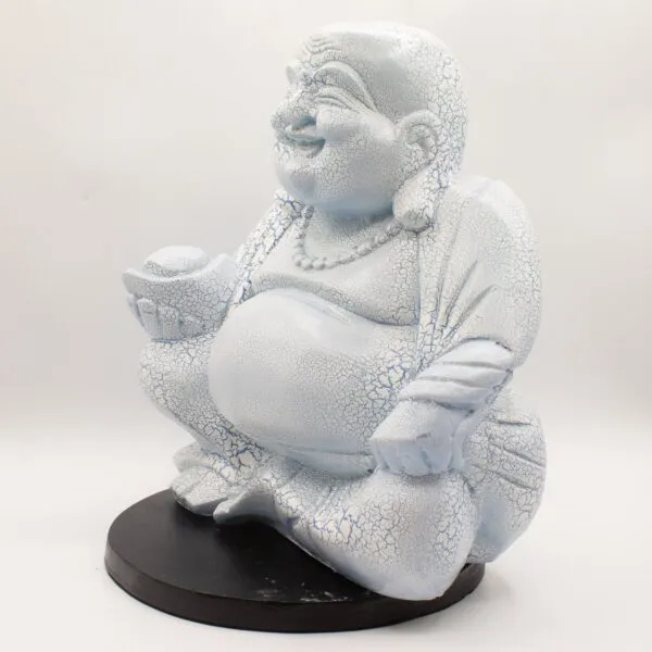 Light blue crackle-glazed Laughing Buddha statue seated cross-legged on a dark circular base.