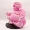 Pink ceramic Laughing Buddha statue with a crackle glaze, holding an offering bowl.