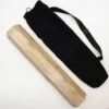 A light-brown wooden box and a black canvas bag on a white surface.
