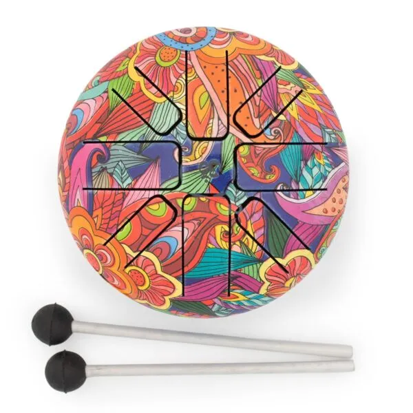 Colourful floral steel tongue drum with two mallets on a light grey surface.