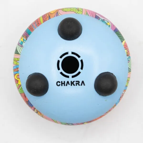 Sky-blue steel tongue drum base with three black rubber feet and a colourful rim.