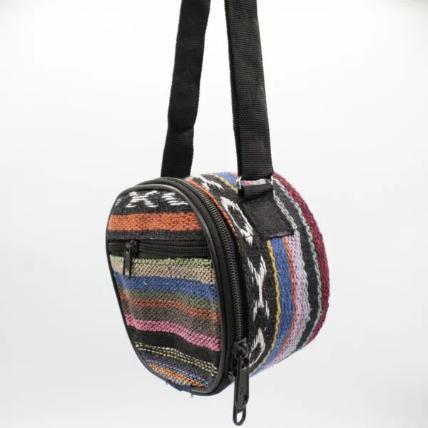 A colourful handmade Nepalese woven fabric messenger bag with circular panels and black strap.