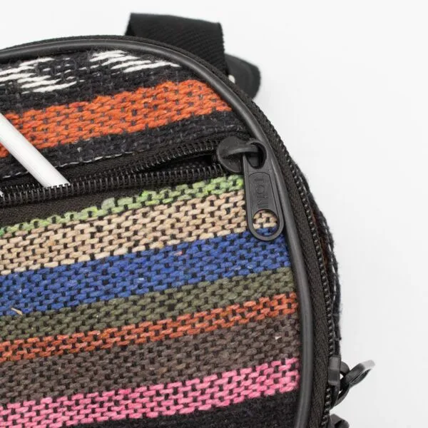 A colourful geometric-patterned camera bag with a black zip on a white background.