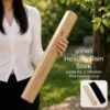 Healing Rain Stick Faceted Wood Natural 50cm With Case Woman holding a 50cm wooden healing rain stick in a garden with carrying case.