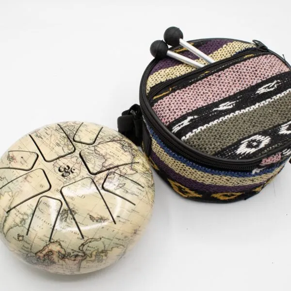 Steel tongue drum with an antique world map print, a colourful woven bag, and mallets.