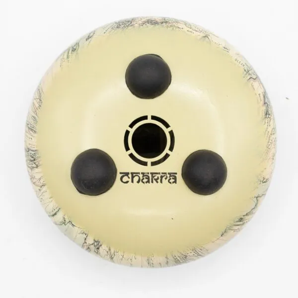 Overhead view of a circular beige handpan with a vintage world map rim.