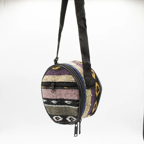 Colourful round Andean woven cross-body shoulder bag with black straps.
