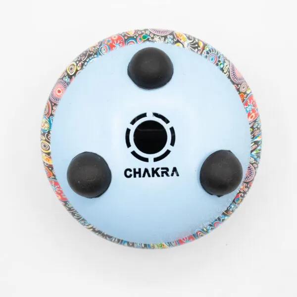 Underside of a light blue steel tongue drum with a colourful paisley pattern.