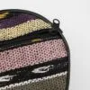 Close-up of a circular colourful striped woven fabric case with a black zipper.