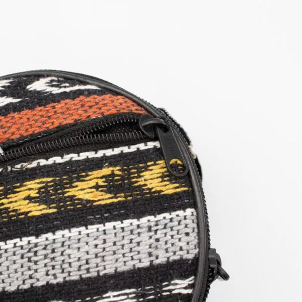 Close-up of a patterned woven bag featuring a black zip pull marked TONI.