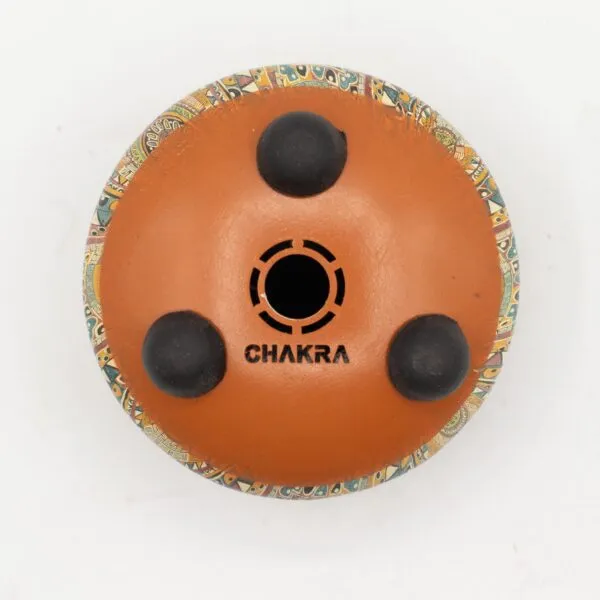Underside of a reddish-brown Chakra drum featuring a colourful patterned rim and rubber pads.