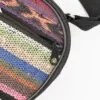 Close-up of a colourful woven striped bag with a black zipper.