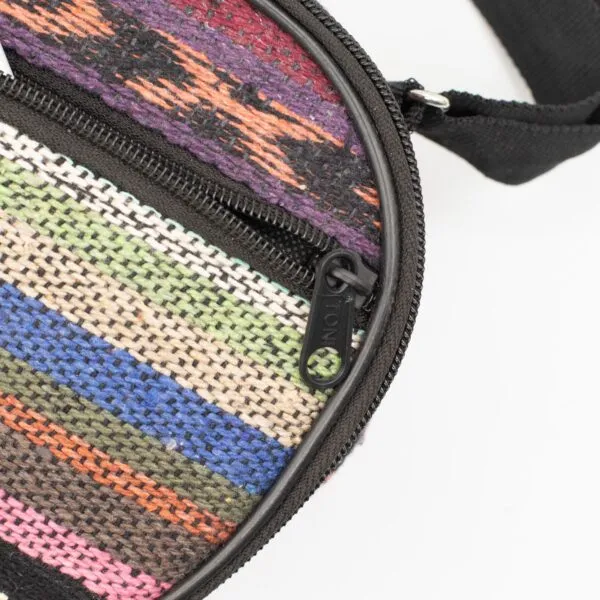 Close-up of a colourful woven striped bag with a black zipper.