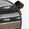Close-up of a round woven bag with a black zip and geometric patterns.