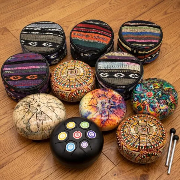 Colourful patterned steel tongue drums and carrying bags arranged on a wooden floor.
