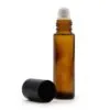 Amber glass essential oil roller bottle with metal rollerball and detached black cap.