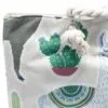 Beige canvas tote bag featuring an embroidered llama and cactus pattern with rope handles.