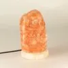 Raw pink Himalayan salt lamp mounted on a polished white marble base.
