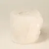 Carved white rock salt pillar tea light holder with a natural crystalline texture.