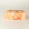 Hand-carved pink Himalayan rock salt double tea light candle holder with two candles.