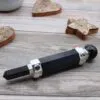 Black onyx crystal healing wand with a silver filigree crown on rustic grey wood.