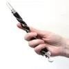 Ornate Magic Wand Wire Wrapped Black And Silver Crystal Tip Hand holding an ornate black and silver wire-wrapped magic wand with a crystal tip.