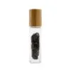 Clear glass rollerball bottle with a bamboo cap, filled with polished black gemstone chips.