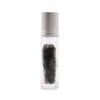 Clear glass roller bottle filled with dark black tourmaline gemstone chips and silver cap.