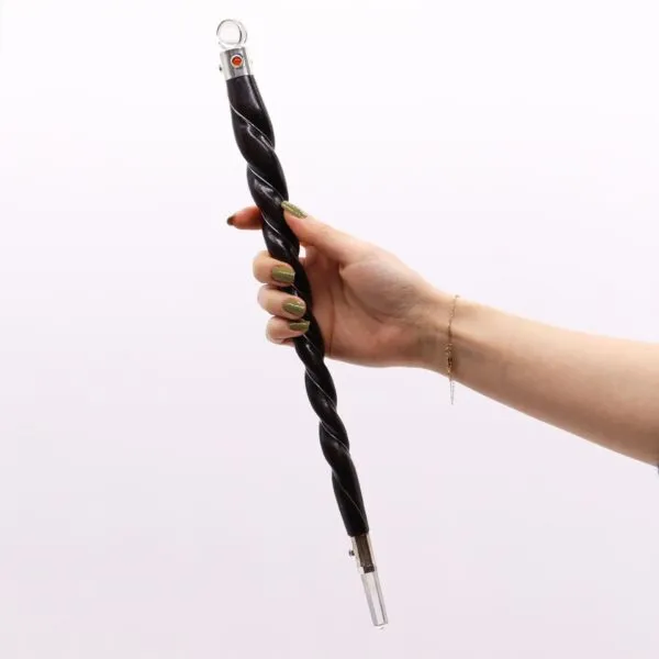 Hand holding a black twisted crystal wand with a clear quartz point.