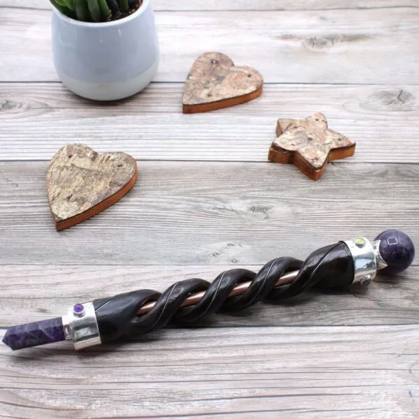 Magic Wand Carved Wood Brown With Amethyst Helix Handle Carved brown wooden magic wand with a purple amethyst crystal helix handle.