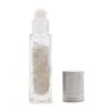 Clear glass essential oil roller bottle filled with white quartz crystals and silver cap.