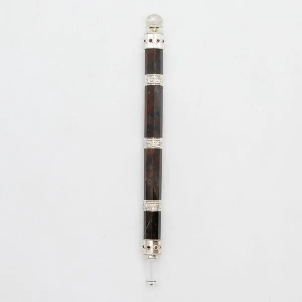 Hexagonal dark wooden magic wand with filigree metal ferrules and a clear crystal point.
