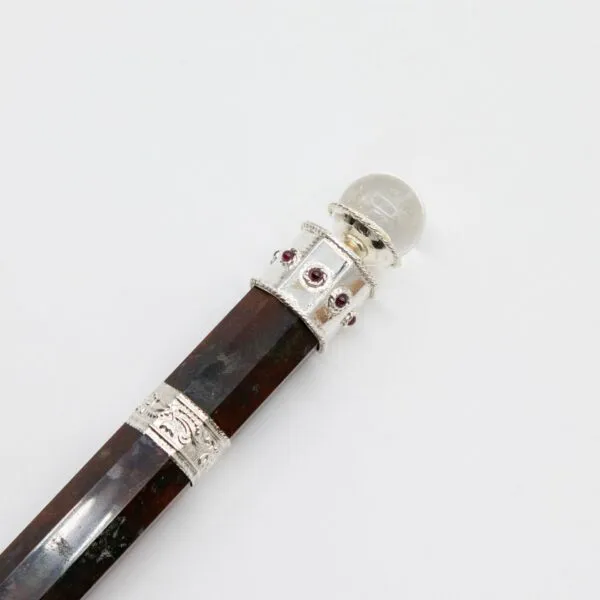 Handcrafted dark wood magic wand featuring ornate silver filigree and red ruby gemstones.