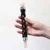 Rose Quartz Crystal Wand Ebonised Wood Black Gem Sphere Hand holding a handcrafted rose quartz and ebonised wood crystal wand.