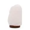 Unpolished light pink Himalayan rock salt lamp on a dark wooden base.