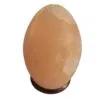 Egg-shaped pink Himalayan salt lamp on a dark wooden base.