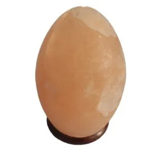Egg Shaped Salt Lamp Himalayan Crystal Pink Wooden Base Egg-shaped pink Himalayan salt lamp on a dark wooden base.