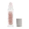 10ml clear glass rollerball bottle filled with rose quartz crystals beside a silver cap.