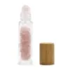 Rose Quartz Rollerball Bottle Clear Glass Pink Wooden Cap Clear glass rollerball bottle filled with rose quartz crystals and a natural wooden cap.
