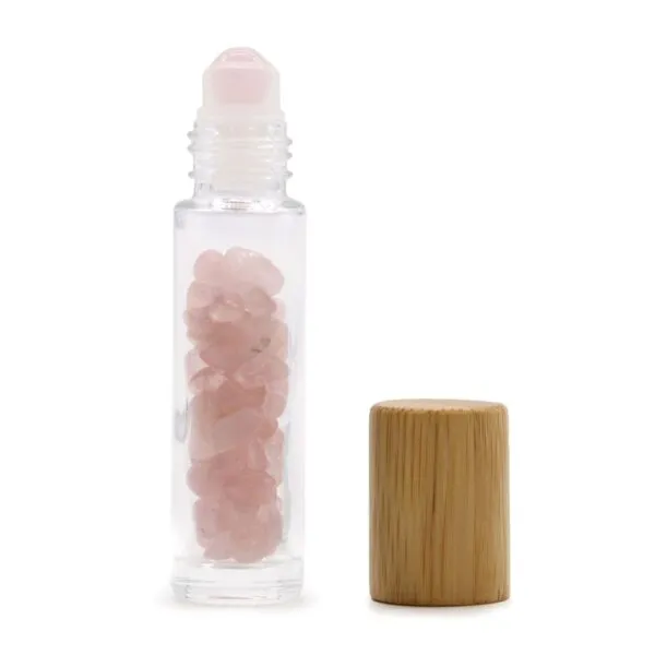 Rose Quartz Rollerball Bottle Clear Glass Pink Wooden Cap Clear glass rollerball bottle filled with rose quartz crystals and a natural wooden cap.