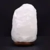 A glowing raw white salt crystal lamp mounted on a dark wooden base.