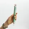 Crystal Healing Wand Gemstone Green Rose Quartz Orb and Point Hand holding a green crystal healing wand with a rose quartz orb and point.